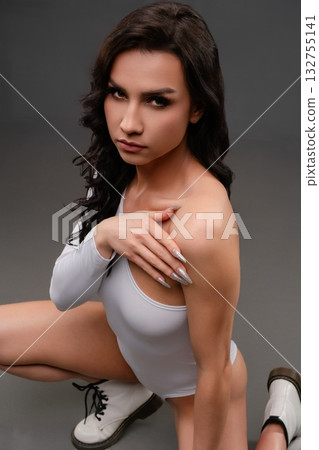 Woman poses in lingerie with an edgy style and fierce expression indoors 132755141