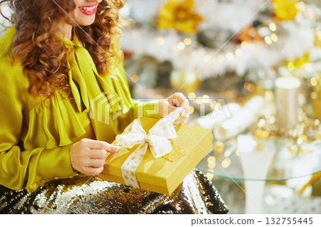 Festive Joy: Woman with Golden Christmas Present Festive Joy: Woman with Golden Christmas Present 132755445