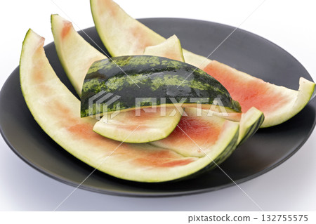 Watermelon rind leftover on a black plate with white background, used in Thai cooking Watermelon rind leftover on a black plate with white background, used in Thai cooking 132755575