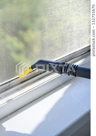 Cleaning window with steam cleaner indoors close-up. 132755670