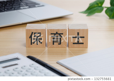 桌上放著一個寫著「育兒工作者」字樣的積木。 132755681