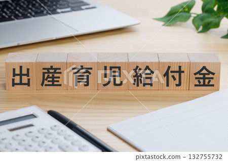 桌上放著一個寫著「產假和育嬰福利」字樣的方塊。 132755732