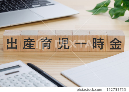 桌上放著一個寫著「一次性生育和育兒補助金」字樣的方塊。 桌上放著一個寫著「一次性生育和育兒補助金」字樣的方塊。 132755733