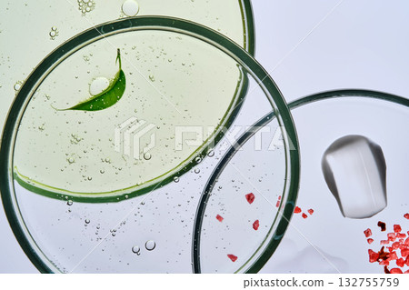 Three petri dishes with cosmetics on a white background. 132755759