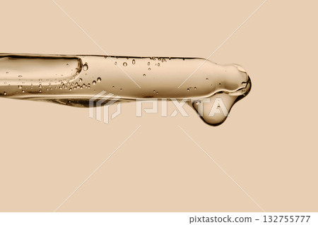 Serum in a pipette close-up on a beige background. 132755777