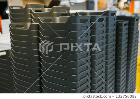Stack of black plastic storage bins in warehouse setting 132756082