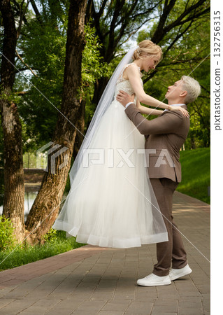 Couple celebrating love in a beautiful park during a wedding ceremony 132756315