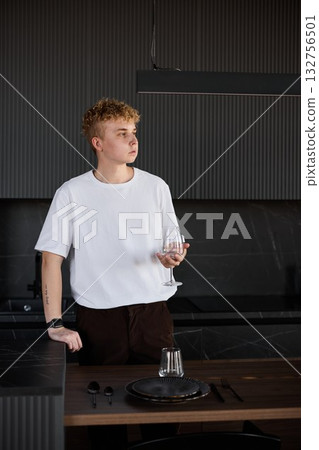 Young man pauses while serving near bright window with reflective Young man pauses while serving near bright window with reflective 132756501