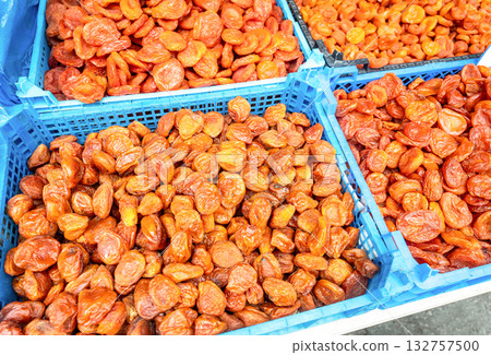 Organic dried apricots in plastic crates at a farmers market. Large pile of dried apricots, dried fruits, healthy dessert, vegetarian food 132757500