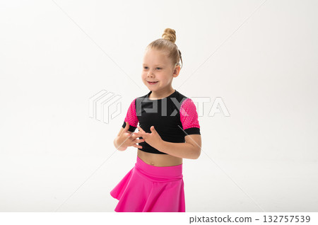 Little girl with hearing implant dancing in black and pink costume, copy space. Overcoming deafness with technology, creativity, and the expressive joy of inclusive childhood art. 132757539