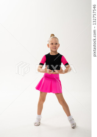 Smiling girl in pink dance outfit with cochlear implant performing studio pose. Celebration of hearing restoration, inclusion, and artistic confidence in children dance and movement. Smiling girl in pink dance outfit with cochlear implant performing studio pose. Celebration of hearing restoration, inclusion, and artistic confidence in children dance and movement. 132757546