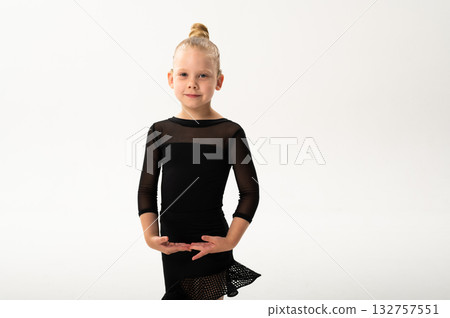 Smiling child in black ballroom outfit practicing elegant movement with hearing technology cochlear implant. Strength, inclusion, and artistic discipline harmonize to celebrate diversity and human 132757551