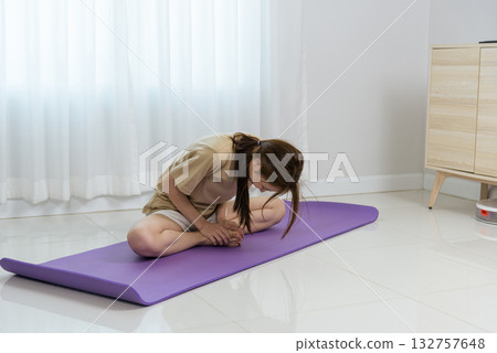Young woman, happy people find home activity beneficial, stretching on yoga mat for wellbeing and good health, daily exercise promoting flexible body and calm mind. Young woman, happy people find home activity beneficial, stretching on yoga mat for wellbeing and good health, daily exercise promoting flexible body and calm mind. 132757648