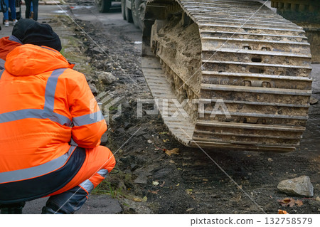 Road works.Driver inspects the damage to the track of a tractor,bulldozer Road works.Driver inspects the damage to the track of a tractor,bulldozer 132758579