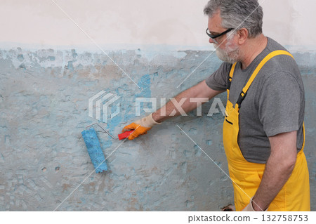 Worker preparing wall for tile gluing Worker preparing wall for tile gluing 132758753