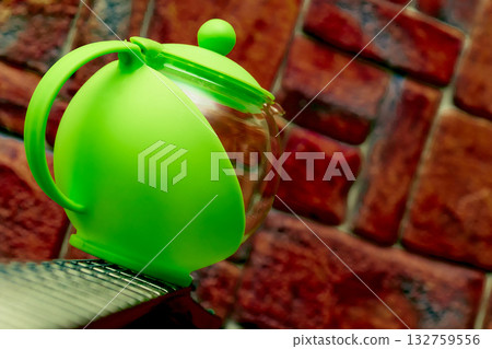 Tea time.Green glass teapot for brewing tea, infusion of medicinal herbs 132759556