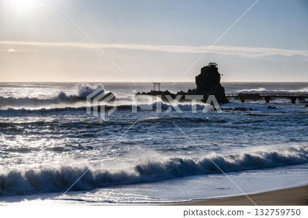 A torii gate towering over the stormy Pacific Ocean A torii gate towering over the stormy Pacific Ocean 132759750