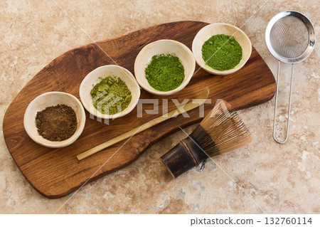 Matcha Tea Ceremony Set, Overhead view of matcha bowls, bamboo whisk, and scoop on a textured surface. Matcha Tea Ceremony Set, Overhead view of matcha bowls, bamboo whisk, and scoop on a textured surface. 132760114