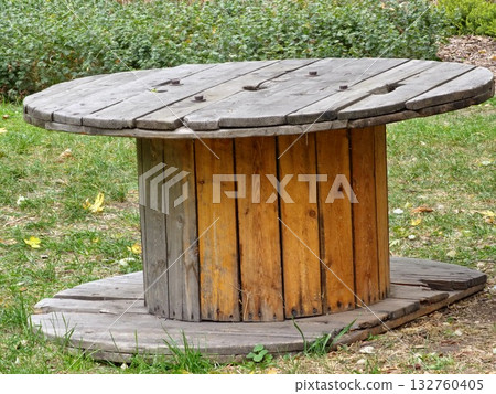 Old wooden cable reel for construction site on the grass. 132760405