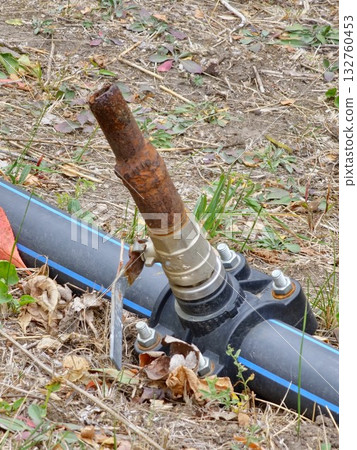An old rusty closed garden tap for watering in botanical garden. An old rusty closed garden tap for watering in botanical garden. 132760453