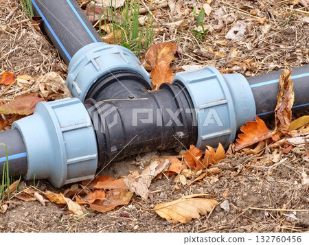 Black and grey plastic pipes for irrigation in a botanical garden. Black and grey plastic pipes for irrigation in a botanical garden. 132760456