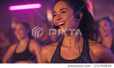 Energetic Female Fitness Instructor Leading Group Workout with Neon Lights 132760699