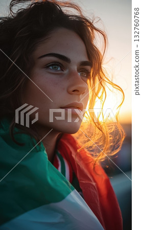 Italian Football Fan Wrapped in Flag at Sunset with Determined Expression 132760768