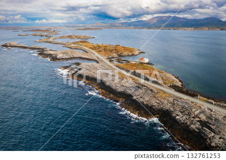 Extensive Atlantic ocean road gracefully weaves across small islands and over narrow channels. Norway challenging coastal geography under cloudy sky 132761253