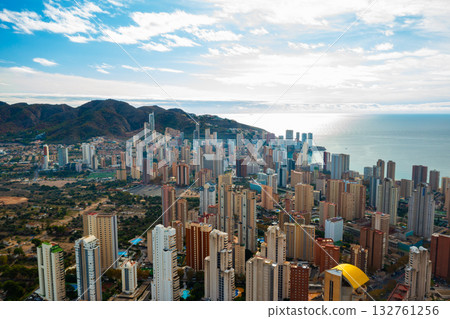 Breathtaking aerial panorama of Benidorm showing its famous high rise buildings, golden beaches, and calm blue waters of the Mediterranean. Sunny coastal resort city in southern Spain with skyline and 132761256