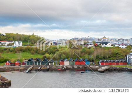 Colorful wooden houses lining the shore of a peaceful fjord in Norway. 132761273