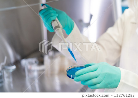 Close up female hands uses pipette for biochemical analysis, preparing agar media in a Petri dish Close up female hands uses pipette for biochemical analysis, preparing agar media in a Petri dish 132761282