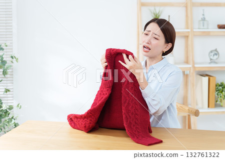 A woman discovers a problem with a sweater she took out for a change of season A woman discovers a problem with a sweater she took out for a change of season 132761322