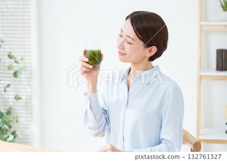 A woman drinking green juice A woman drinking green juice 132761327