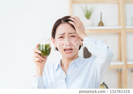 A woman drinking green juice A woman drinking green juice 132761328