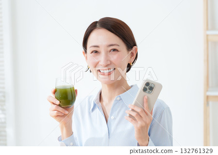 A woman drinking green juice 132761329