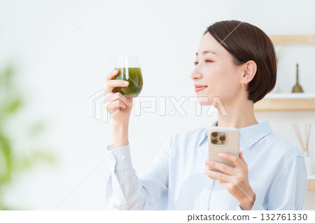 A woman drinking green juice A woman drinking green juice 132761330