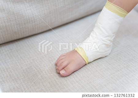 孩子扭傷腳後用膠帶包紮。 132761332