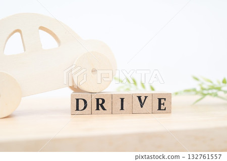 一輛木製小汽車和“DRIVE”字母積木。一件讓人聯想到駕駛和汽車生活的作品。 132761557
