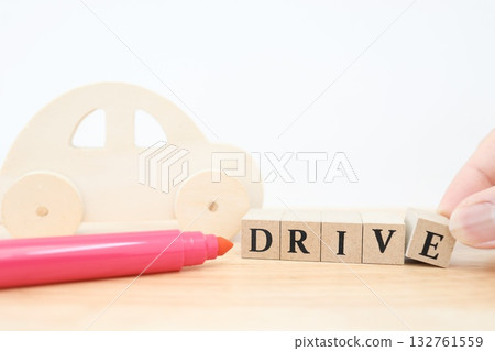 一輛木製小汽車和“DRIVE”字母積木。一件讓人聯想到駕駛和汽車生活的作品。 132761559