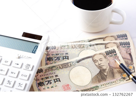 桌上放著一萬日元鈔票和一台計算機。 132762267