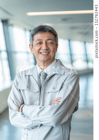 一個穿著工作服、雙臂交叉的男人 132762443