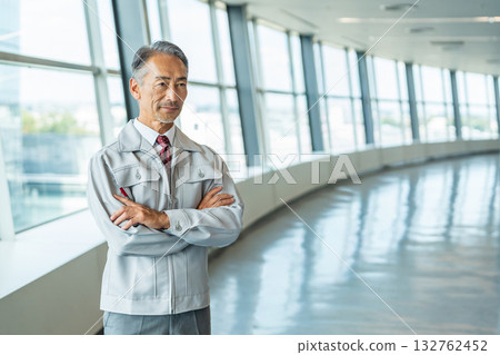 Senior man in work clothes standing in the office lobby Senior man in work clothes standing in the office lobby 132762452