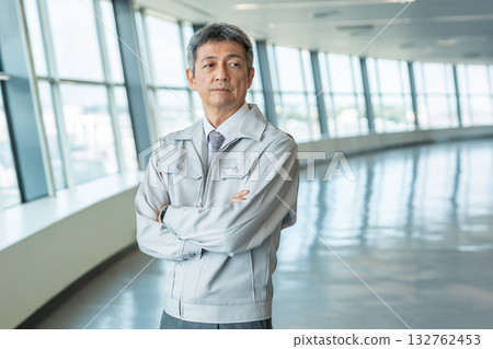 Senior man in work clothes standing in the office corridor Senior man in work clothes standing in the office corridor 132762453