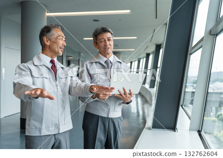 Senior man in work clothes operating a computer at the site 132762604