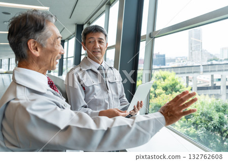 一名身穿工作服的男子正在現場操作電腦。 132762608