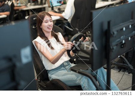 Young woman enjoying a racing game Young woman enjoying a racing game 132763611