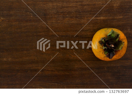 Distressed persimmons on a table in the background, seen from above 132763697
