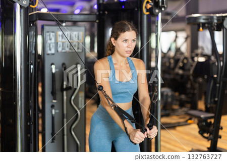 Woman doing exercises for chest muscles in crossover Woman doing exercises for chest muscles in crossover 132763727