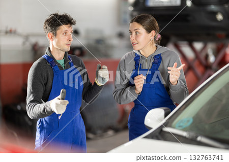 Girl and man auto mechanics talk about algorithm of work, consult with each other 132763741