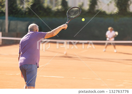 Elderly man playing tennis 132763776